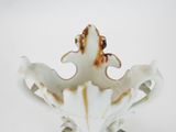 a white vase with a rusted design on it