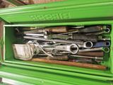 a green box filled with tools and a pair of scissors