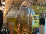 many wine glasses hanging from the ceiling in this store