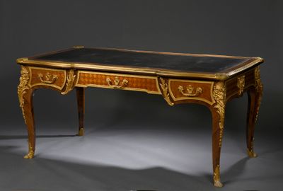 un bureau avec un plateau noir et des ornements dorés