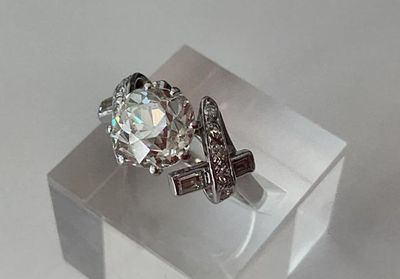 une bague en diamant posée sur une boîte transparente
