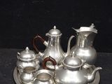 a silver tray with silver teapots and cups on it