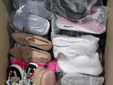 many pairs of shoes in a box with plastic wrap