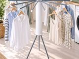 an image of a laundry room with clothes on a clothes rack
