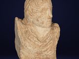 an ancient statue of a man with a beard on a blue background