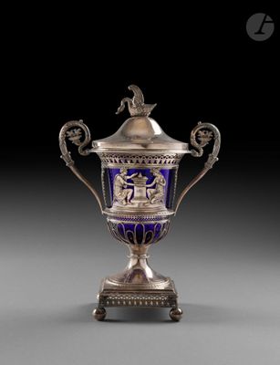 un vase argenté et bleu surmonté d'un oiseau