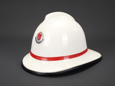 un casque de pompier blanc orné d'une bande rouge autour du bord