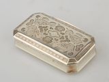 an antique silver cigarette case on a white surface
