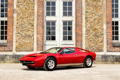 a red sports car parked in front of a brick building
