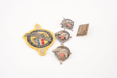 trois insignes et une épingle sont posés sur une surface blanche