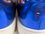 blue sneakers with white soles on a white surface