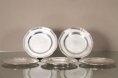 trois assiettes en argent posées les unes à côté des autres sur une table