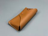 étui en cuir beige muni d'un bouton sur le devant