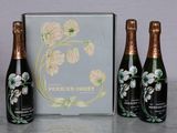 three bottles of champagne sitting next to a box on a table