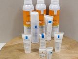 plusieurs flacons de crème solaire et de lotion posés sur un plateau en bois