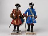 two figurines of two men dressed in military uniforms