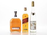 three bottles of liquor sitting next to each other on a white surface