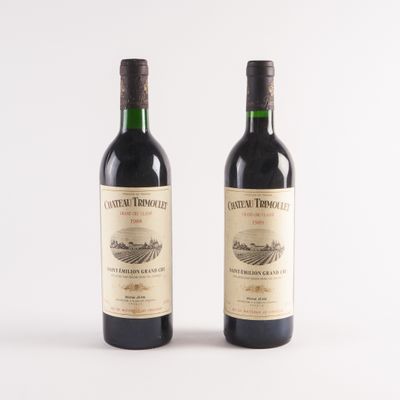 deux bouteilles de vin posées l'une à côté de l'autre sur une surface blanche