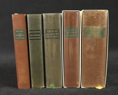trois vieux livres sont alignés sur une surface noire