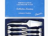 four pieces of silverware in a blue box on a white surface