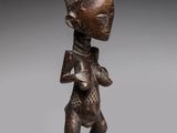 a wooden statue of a woman with a hat on her head