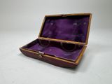 an old wooden box with a purple lining on a white surface