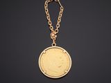 une pièce d'or attachée à une chaîne sur fond noir