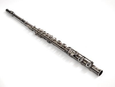a close up of a silver flute on a white surface