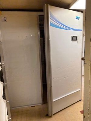 a refrigerator in the corner of a room next to a toilet
