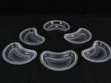 six bols en plastique transparent sont disposés en cercle sur une surface noire