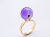 Gros plan sur une bague ornée d'une pierre violette