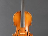 an old violin sits on a stand against a gray background