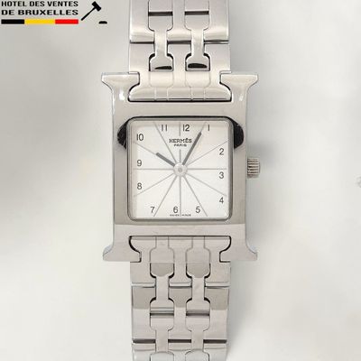 a silver watch with a white face on a silver bracelet