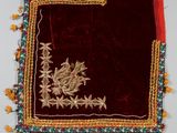 une image représentant un tissu brodé de rouge et d'or, orné de fleurs