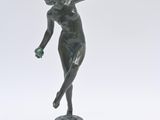 statue d'une femme tenant une raquette de tennis, posée sur une surface blanche