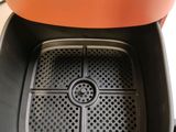 an orange toaster that is sitting on top of a counter