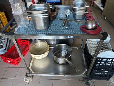 many pots and pans sitting on a metal cart