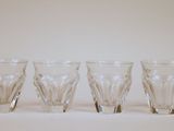 six verres sont alignés sur une surface blanche