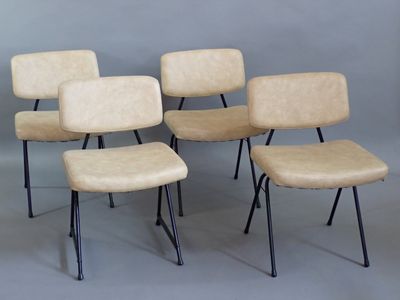 four chairs with black legs and a beige seat on a gray background