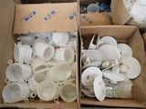 two boxes full of white cups and saucers in them