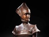 a bronze bust of a woman wearing a hat and dress
