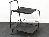 a black trolley with a tray on top of it on a carpeted floor