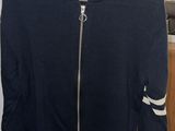navy blue sweater with white stripes on the sleeves and a hoodie on a hanger