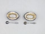 two spoons and a bowl on a white table