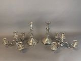 silver plated candlesticks and candelabs on a table