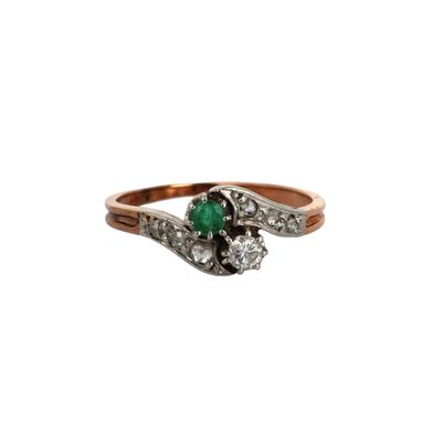 gros plan d'une bague en diamant et émeraude sur fond blanc