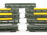 several green and yellow train cars are lined up on a white surface