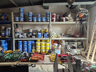 de nombreux pots de peinture sur les étagères du garage