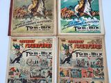 four old comic books are on display on a white surface