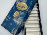 une image représentant une boîte bleue contenant six cuillères en argent